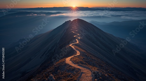 A winding path ascends a mountain ridge, zigzagging toward the rising sun above a layer of clouds