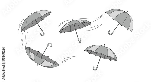 Several umbrellas are being blown around by the wind.
