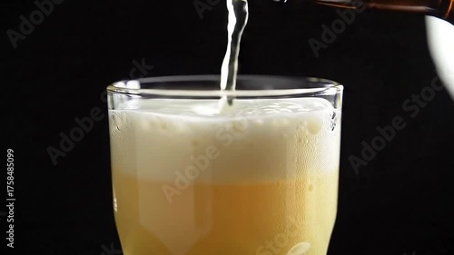 Pouring fresh beer into a glass close up view footage
