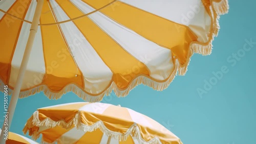 Striped Yellow and White Beach Parasol Under Clear Blue Sky on a Sunny Day
