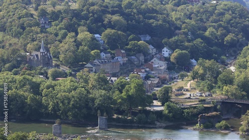 High angle view of historic Harpers Ferry where the Potomac and Shenandoah Rivers meet. The town’s old bridge ruins and church spires highlight its scenic and historic charm on a late summer day.