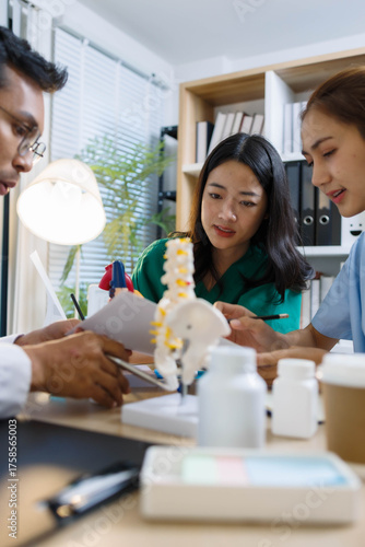 A doctor and a nurse are examining a model of a heart. The doctor is explaining the anatomy of the heart to the nurse
