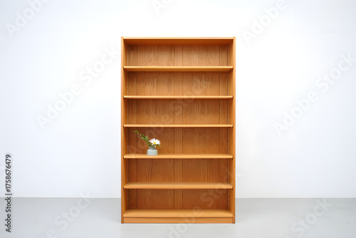 Wooden bookshelf with decorative flower vase isolated on white background