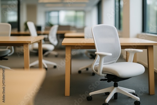 Wallpaper Mural An empty modern open-plan office featuring rows of light wooden desks and white ergonomic chairs, symbolizing a clean, minimalist, and professional workspace. Torontodigital.ca