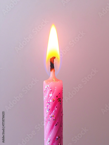Bright Pink Candle with Flickering Flame Against Soft Background