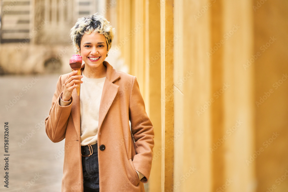 Fototapeta premium Young woman enjoying ice cream on city street