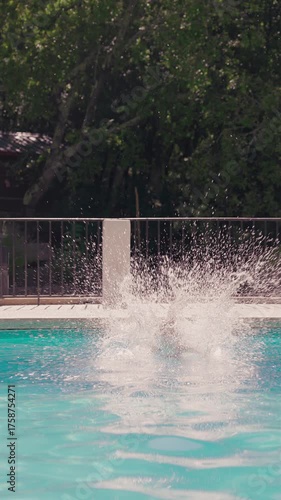 Wallpaper Mural Young girl in swimsuit and goggles jumps into backyard pool on a sunny summer day creating big splash Torontodigital.ca