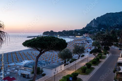Fototapeta Naklejka Na Ścianę i Meble -  Morning view on sunbeds and umbrellas on Mondello Beach, near Palermo in Sicily, popular seaside destination with fine, golden sand, turquoise waters and charming villas