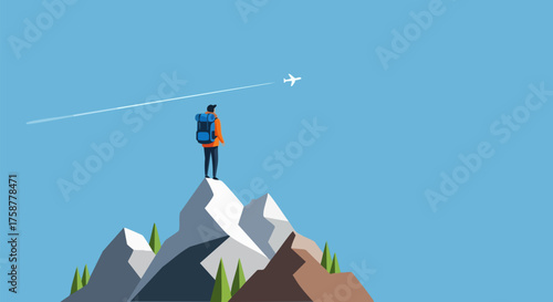 Man with backpack stands atop mountain peak watching airplane fly across blue sky