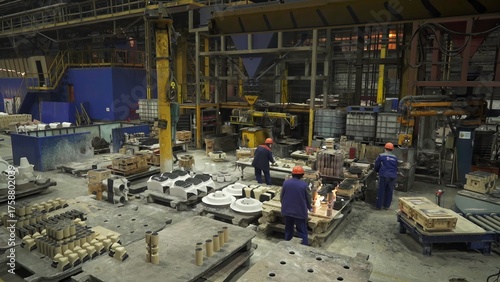 Foundry workers pouring molten metal into molds. Stock clip