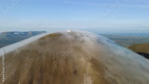 Amazing 4K aerial video of flying above and around Most Famous mountain in Ireland - Croagh Patrick in windy weather, with moving fog and clouds with breathtaking views around, Westport, Ireland
