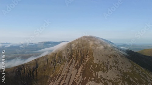 Amazing 4K aerial video of flying above and around Most Famous mountain in Ireland - Croagh Patrick in windy weather, with moving fog and clouds with breathtaking views around, Westport, Ireland
