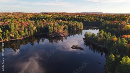 High angle rising view of a lake and forest in autumn