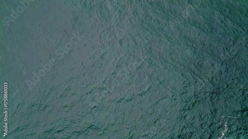 Turquoise ocean water rippling in slow motion top view. Picturesque blue waves