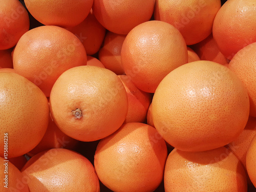 Close-up of bulk red grapefruits. Natural fruit background. Healthy eating. Freshly picked grapefruits for sale.
