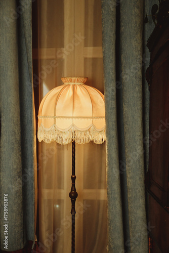beautiful Lampshade in bedroom.old floor lamp with a hole with a fringe.Room decoration in retro style, furniture details and old lamps by the window.Vintage floor lamp