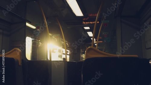Cinematic view inside a moving train carriage with empty seats and warm sunlight streaming through the window. The screen shows upcoming stops. Peaceful travel atmosphere, perfect for lifestyle and jo