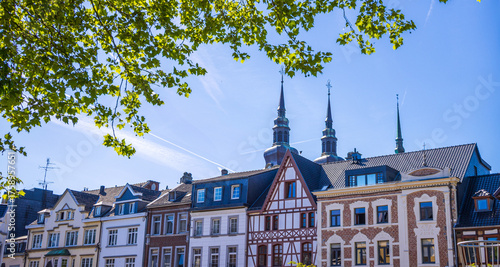 Die Türme von St. Nikolaus in Euoen, Belgien ragen über die Häuser am Markt