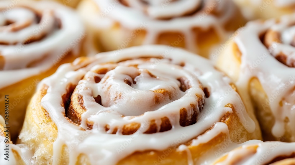 Fototapeta premium Delicious close up of fluffy cinnamon rolls topped with creamy icing for a sweet treat