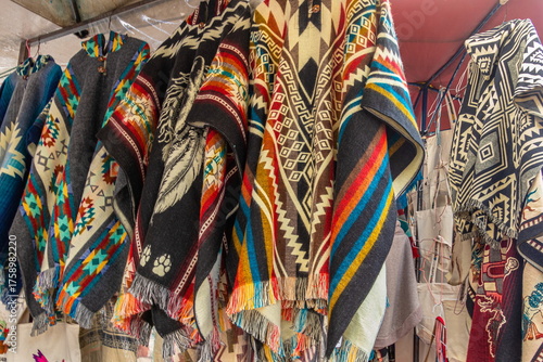 Traditional Andean ponchos in a variety of colors are displayed for sale at the weekly Plaza de los Ponchos market in Otavalo, Ecuador