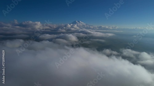 A view of the snow-capped peaks of Mount Elbrus above the clouds. Landscape and nature of the North Caucasus