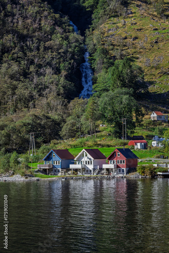 Houses at the bottom of a waterfall in Bakka, Norway
