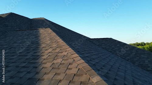 Aerial Drone Footage Showcases Residential Roof Shingles Under Clear Blue Sky