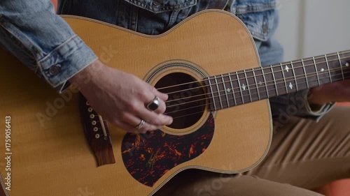 Man Playing Acoustic Guitar in Denim Jacket Indoors