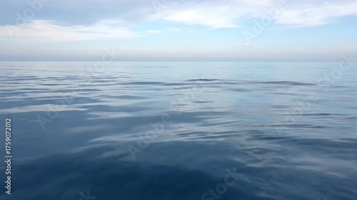 Serene ocean landscape depicting a tranquil scene with water, subtle waves, and a partly cloudy sky