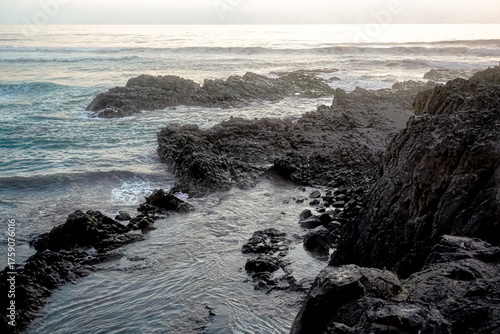 Canvas-taulu Dramático paisaje costero con poderosas olas rompiendo contra rocas escarpadas al atardecer