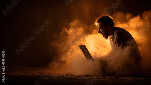 Furious man screams in frustration while using laptop amid smoke.