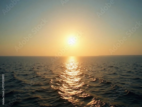 Golden sunlight reflecting on ocean waves during a beautiful sunset over the horizon.