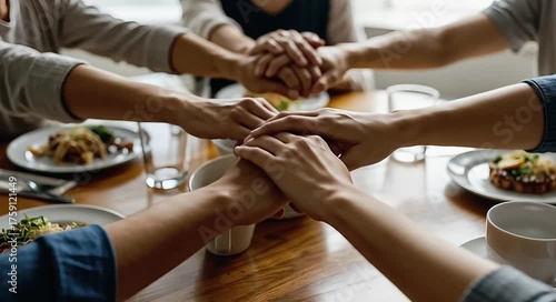 Hands joining together in unity over dinner table at home  