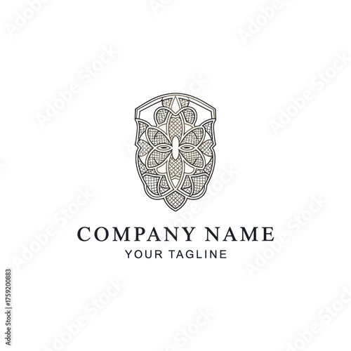 Elegant ornamental shield logo design with butterfly and intricate patterns.