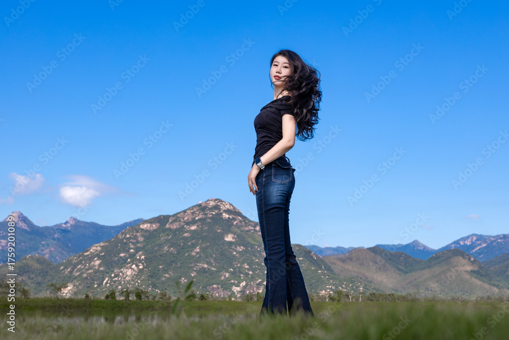 Naklejka premium A long legged beauty wearing jeans at the Yinhu Bay Wetland Park in Jiangmen