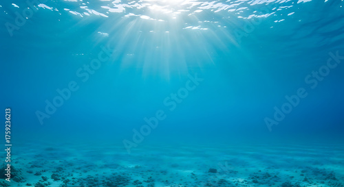 Fototapeta Naklejka Na Ścianę i Meble -  Underwater Ocean Background with Sun Rays and Sandy Bottom, Deep Blue Water and Light Beams Penetrating the Surface
