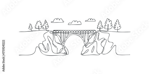 Arch bridge over gorge with trees and clouds