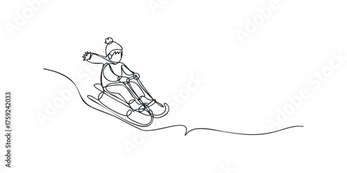 Child sledding downhill on a winter day