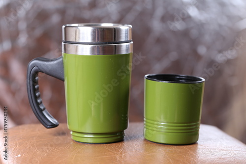 Green travel sippy thermal mug on black background