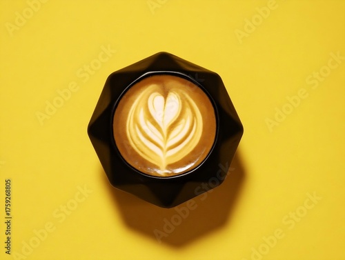 a cup of black coffee with heart-shaped latte art on a bright orange table.