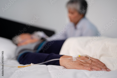 scene of bedridden patient, focus on hand of illness elderly hopeless senior man lying on bed. home caregiver nurse visit retirement patient for health check up recovery process medical service