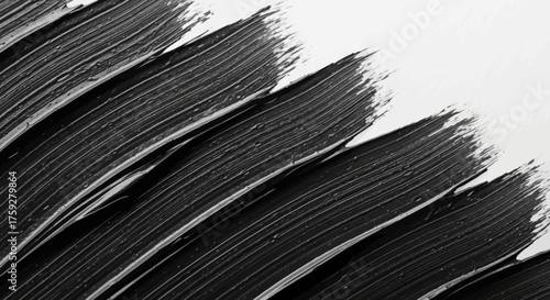 Abstract strokes of black paint creating a textured pattern against a stark white background suggesting artistic expression and minimalist design