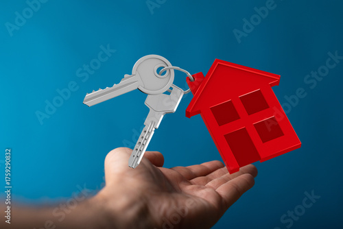 A hand holds keys and a hou...