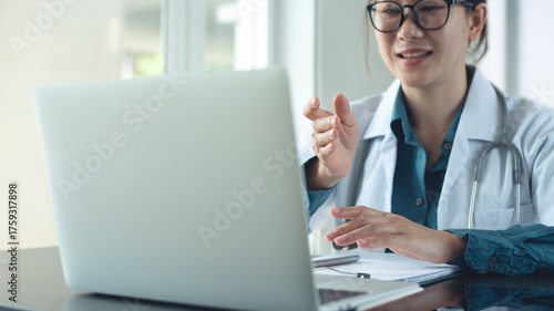Asian female doctor using laptop computer online video call, telemedicine to patient, prescribe medicine. Tele medical, health care service. Doctor online meeting with medical team via laptop