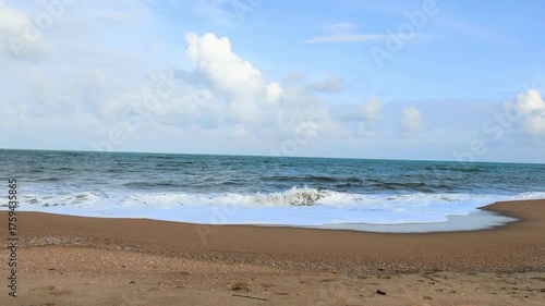 Experience the serenity of a tropical beach where gentle waves caress soft sand under a sky filled with drifting clouds. The ocean breeze and distant horizon create a peaceful escape into nature’s.