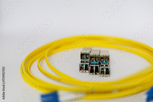 Enabling high-speed data transmission, this coiled fiber patch cord and its blue connectors work in tandem with SFP modules within modern optic networks.