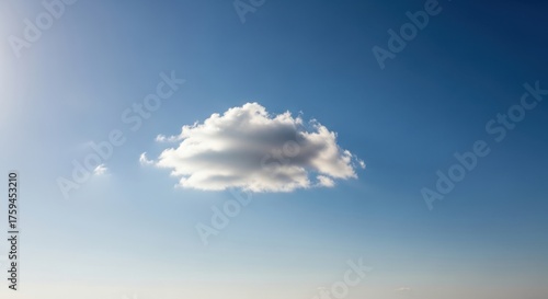 A single, fluffy white cloud floats serenely in a vast, clear blue sky on a bright, sunny day, evoking a sense of peace and solitude