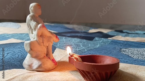 Slow-motion horizontal shot from India, a hand delicately lights a diya against a black background, capturing the essence of spiritual preparation and the vibrant warmth of Diwali festival celebration