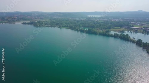 Aerial View of Turquoise Lake with Green Forest Shoreline and Misty Horizon