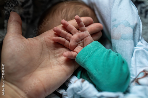 Newborn baby holding parents hand